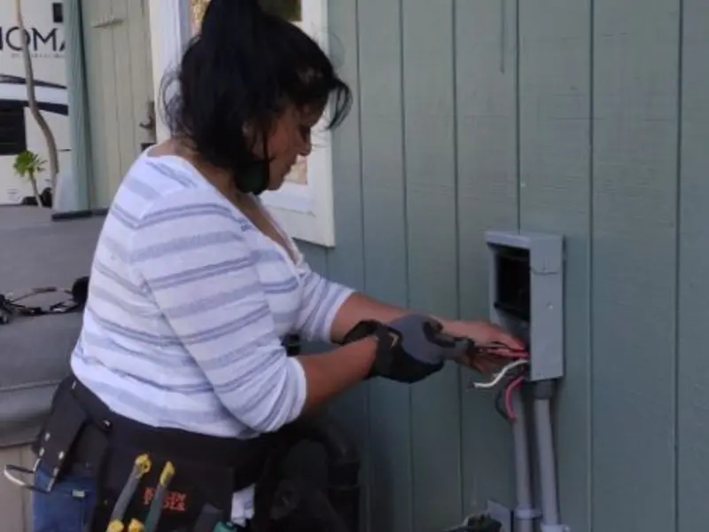 Licensed electrician wiring an exterior subpanel in Rogers